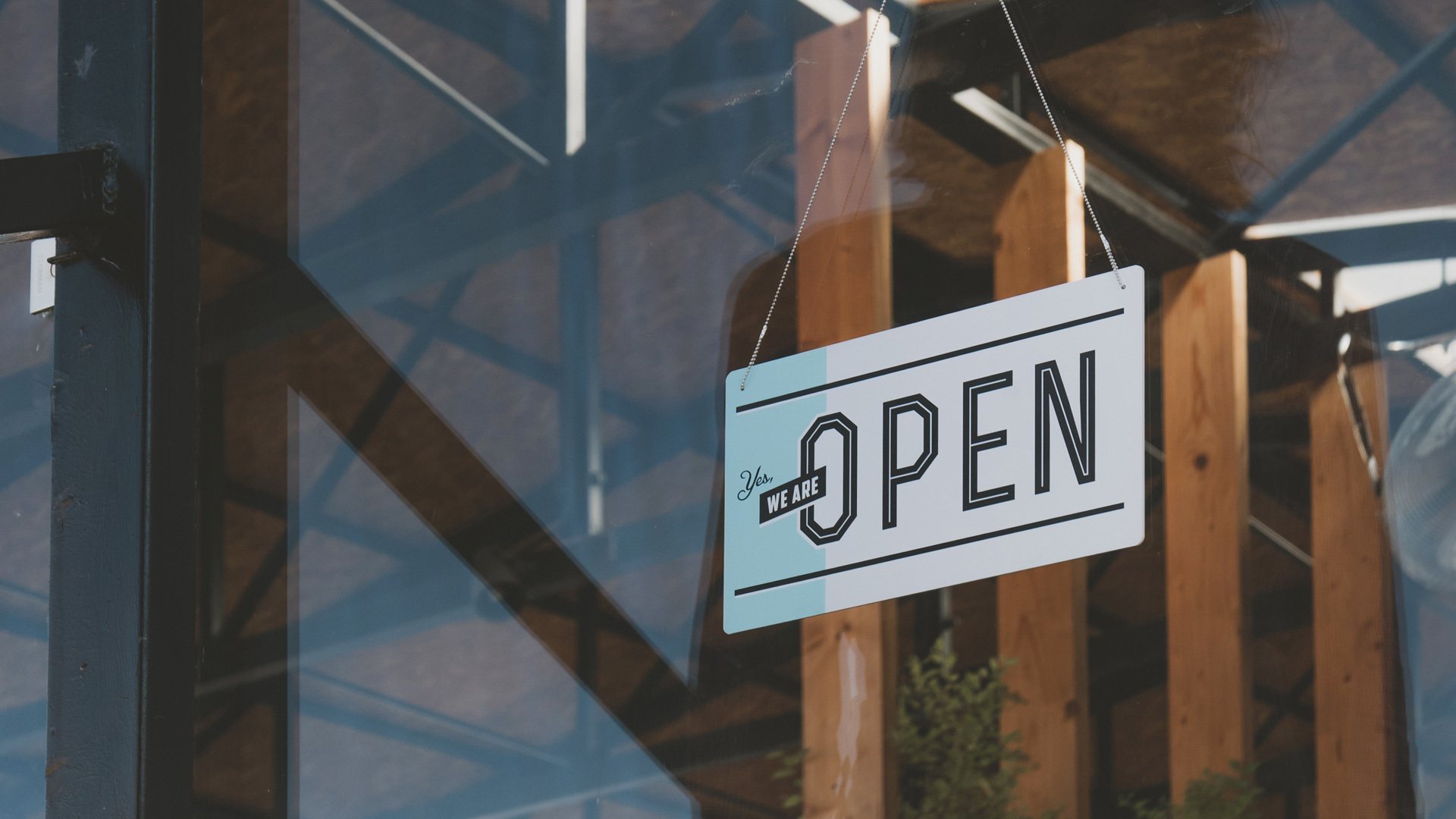 An open sign hanging in a shop window